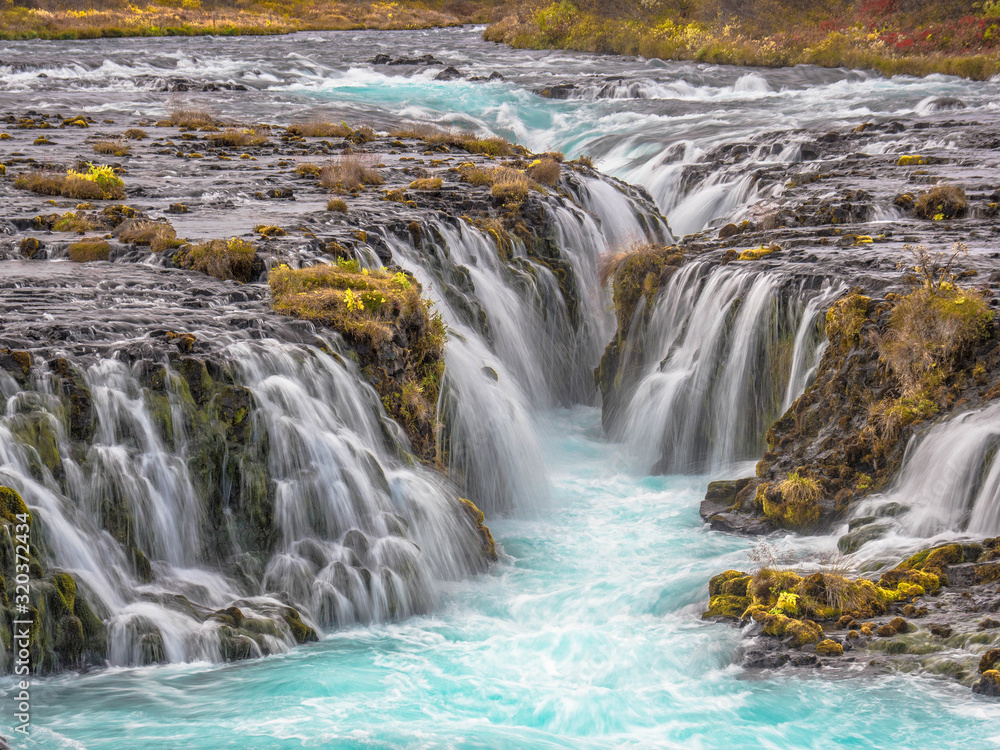 The Brúarfoss Waterfall is one of the nicest Waterfalls with blue Water  this picture has beautiful autumn scenery