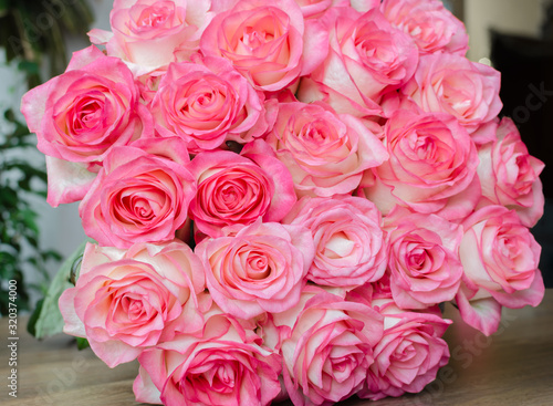 bouquet with delicate fragrant rose flowers on a wooden background, a gift for the holiday