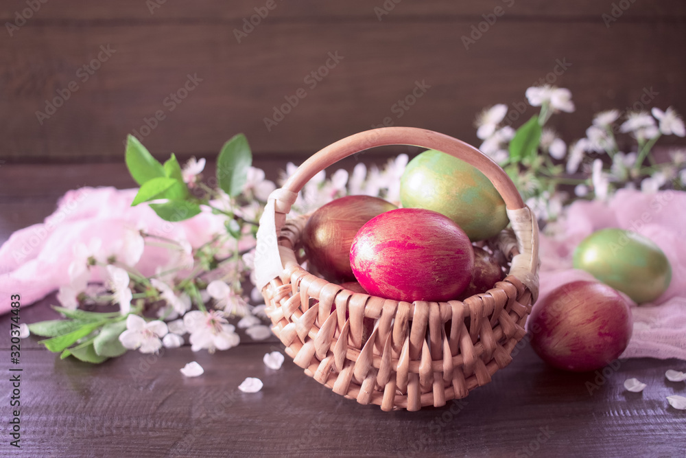 Easter multicolored eggs in a wicker basket and spring flowers close-up. Easter background with eggs in a basket and flowers. Easter multicolored eggs in a wicker basket and spring flowers close-up. Easter background with eggs in a basket and flowers.