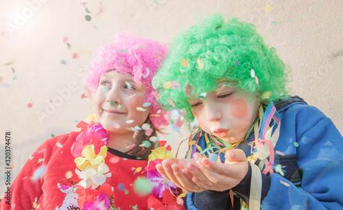Funny Children girls celebrate carnival smiling and having fun with  colorful confetti