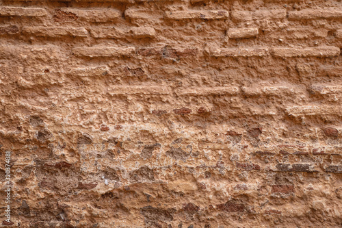 Crumbling brown mud brick wall texture