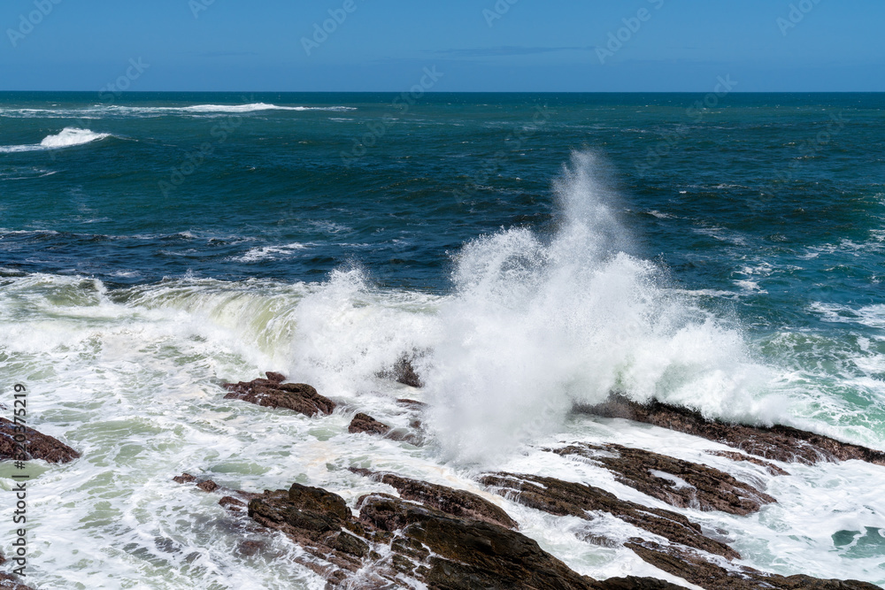 Fototapeta premium Felsküste mit Meeresbrandung und Wasserspritzern 