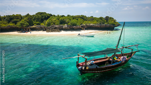 Beautiful exotic island with a private beach and a boat docked in Zanzibar Tanzania © LP Productions