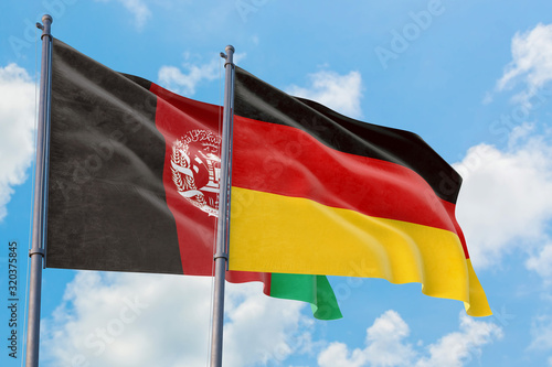 Photos Germany and Afghanistan flags waving in the wind against white cloudy blue sky together