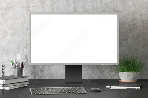 Workspace with blank computer monitor white screen mock up on the black desk near concrete wall. monitor; screen; computer; mock up;