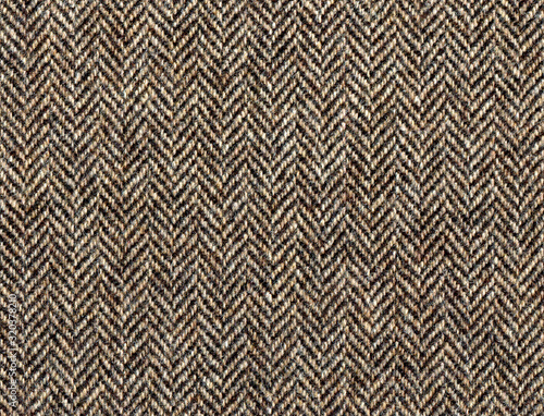 Beige woolen fabric striped zigzag. Classic Herringbone tweed, Wool Background Texture. Coat close-up. Expensive men's suit fabric. High resolution
