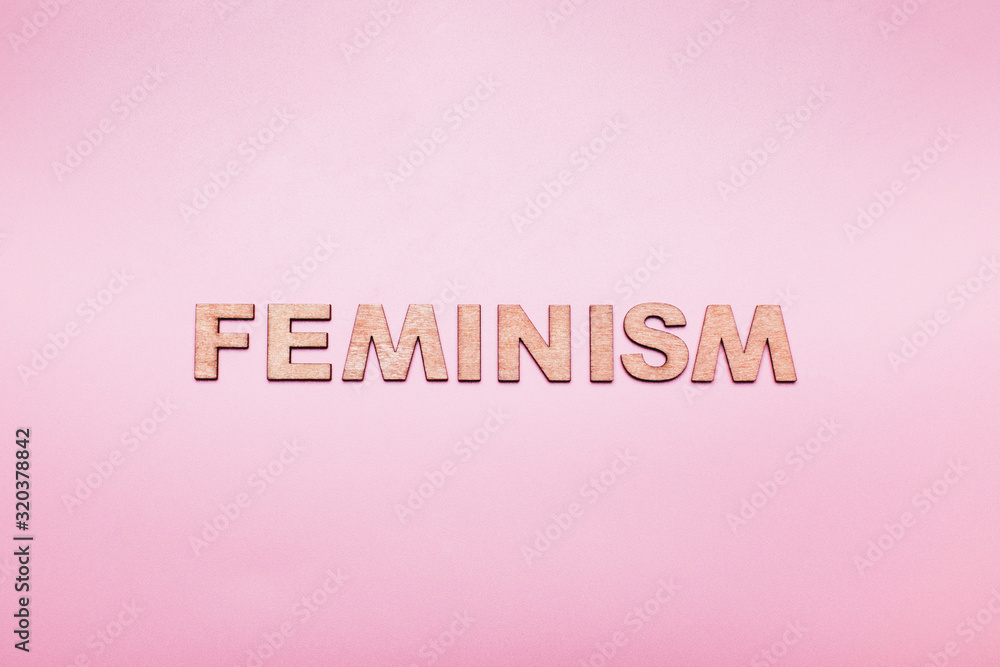 The word feminism on a pink background