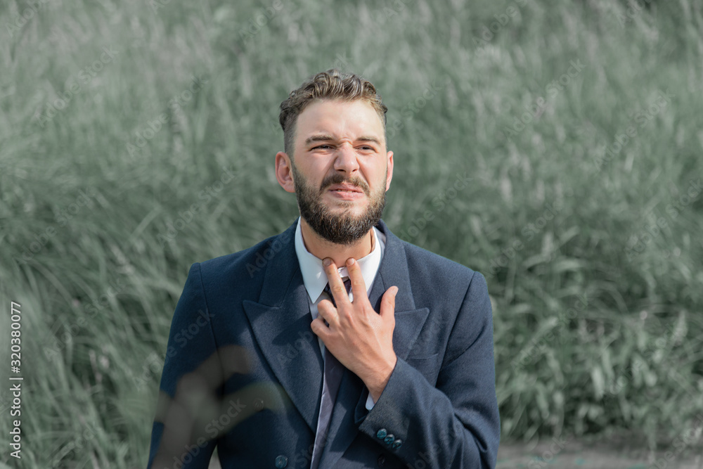 a man in a business suit in a swamp put his fingers to his throat a man in a business suit in a swamp put his fingers to his throat