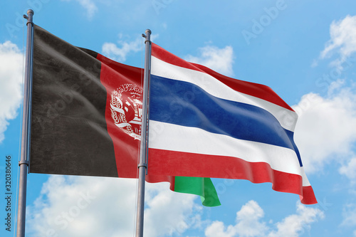 Thailand and Afghanistan flags waving in the wind against white cloudy blue sky together. Diplomacy concept  international relations.