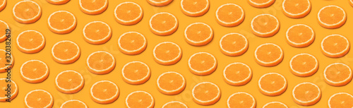 Foto pattern with orange citrus fruits on a orange background, panoramic  image in po