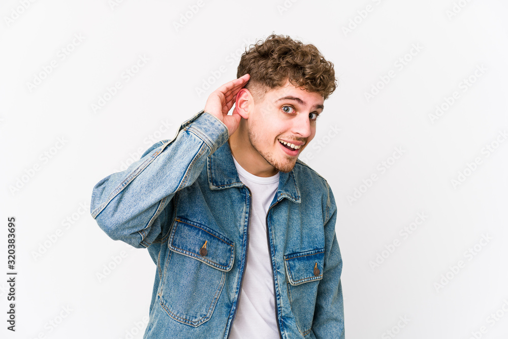 Young blond curly hair caucasian man isolated trying to listening a gossip. Young blond curly hair caucasian man isolated trying to listening a gossip.