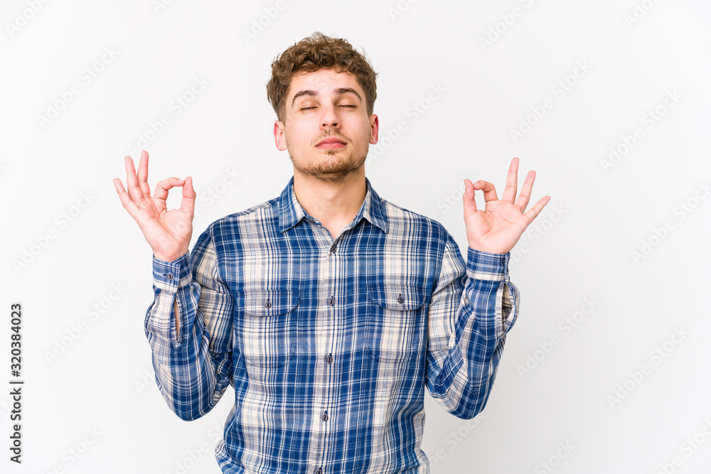 Young blond curly hair caucasian man isolated relaxes after hard working day, she is performing yoga. Young blond curly hair caucasian man isolated relaxes after hard working day, she is performing yoga.