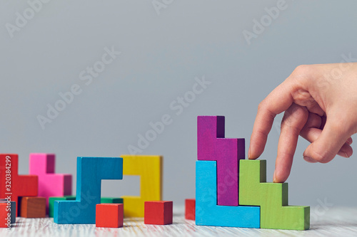 Stacked cubes and female hand imitating walking upstairs against white background. Concept of progress