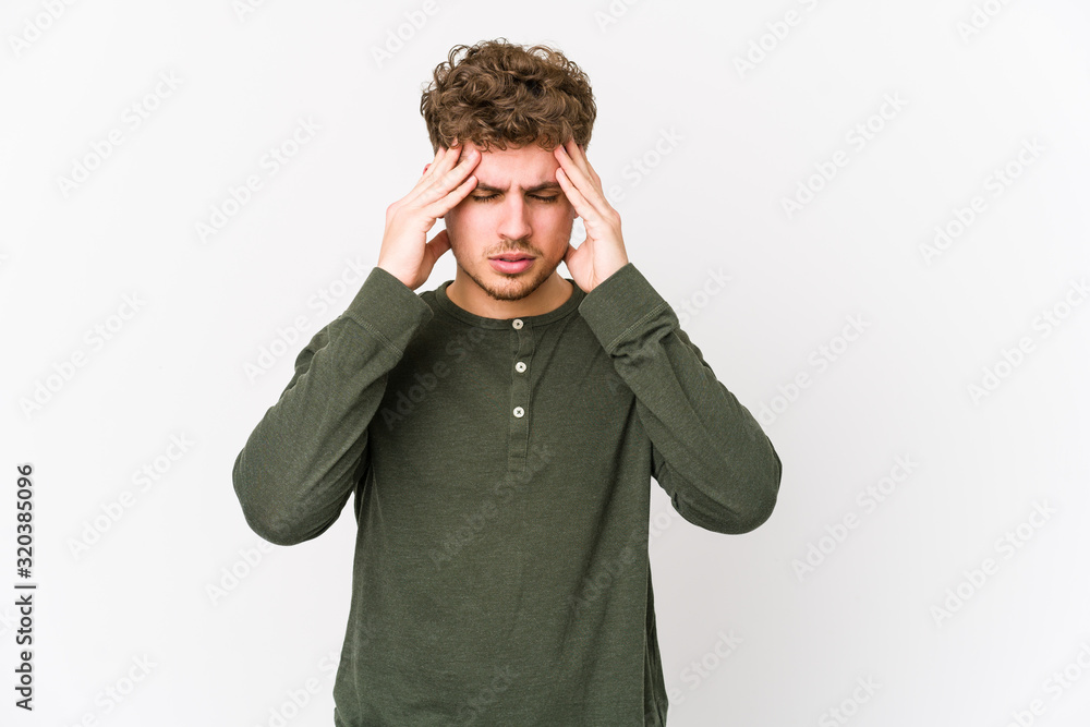 Young blond curly hair caucasian man isolated touching temples and having headache. Young blond curly hair caucasian man isolated touching temples and having headache.