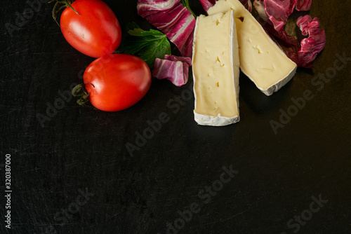 Quadro em tela Cheese delikatessen closeup on black stone desk surface