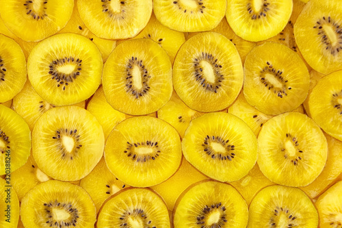 Kiwi Gold fruit background. Fresh juicy yellow kiwi slices with black seeds, top view