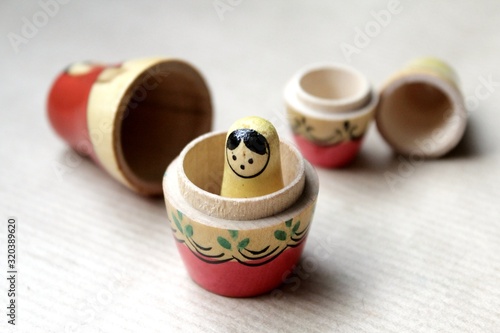 Wooden Russian matryoshka dolls in folk style, girls with painted dresses and veiled heads covered with babushka shawl. A little girl is lost, alone and frightened photo