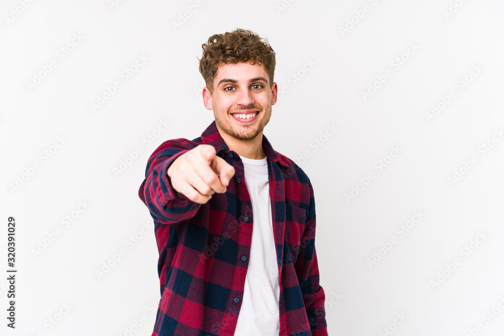 Obraz premium Young blond curly hair caucasian man isolated cheerful smiles pointing to front.