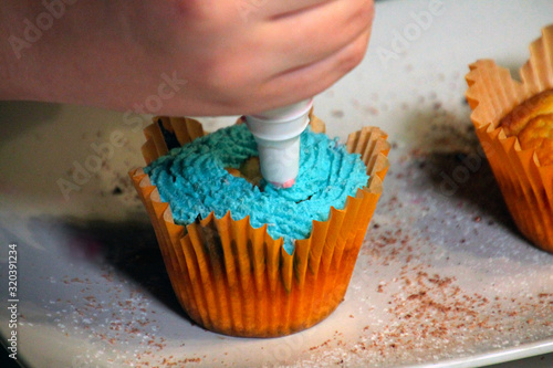 cupcake with blue cream and sprinkles in yellow form