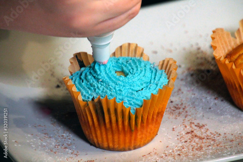 cupcake with blue cream and sprinkles in yellow form