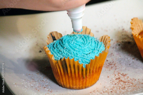 cupcake with blue cream and sprinkles in yellow form