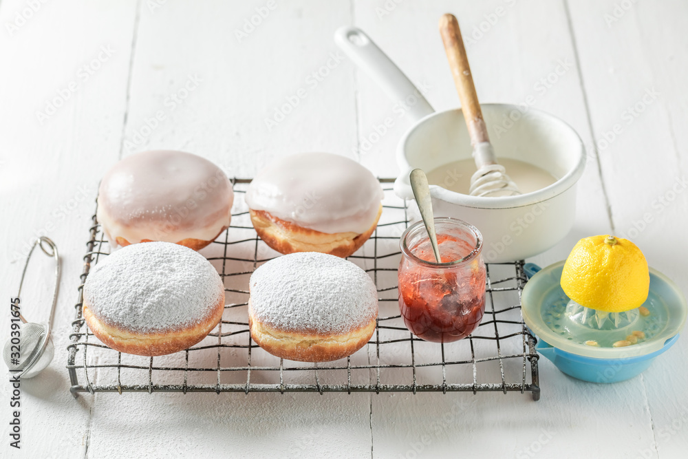 Sweet and fresh donuts on cooling grate on white table Sweet and fresh donuts on cooling grate on white table