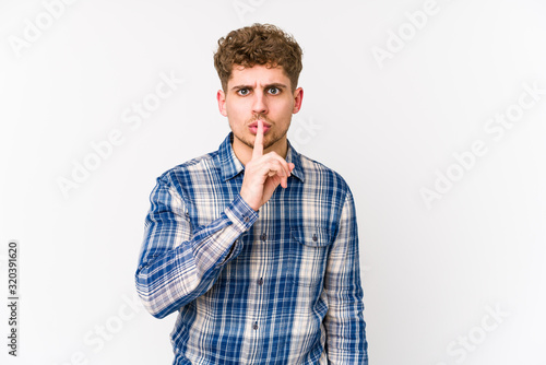 Young blond curly hair caucasian man isolated keeping a secret or asking for silence.