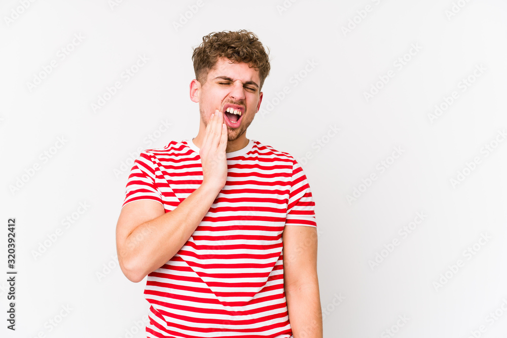 Young blond curly hair caucasian man isolated having a strong teeth pain, molar ache. Young blond curly hair caucasian man isolated having a strong teeth pain, molar ache.