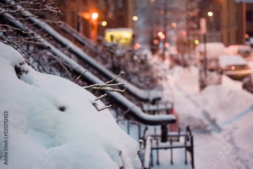 Looking down a snow-covered street with blurry bokeh balls in the background, in Harlem, New York, NY, USA