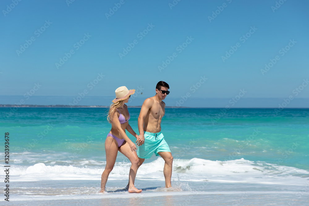 Young couple walking besides the beach