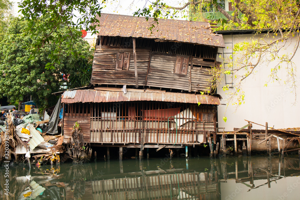 old dilapidated wooden house on the banks of the river canal old dilapidated wooden house on the banks of the river canal