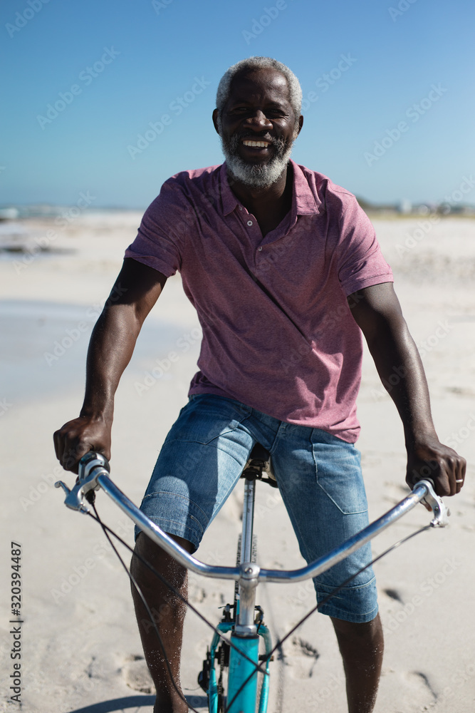 Obraz premium Old man with a bike at the beach