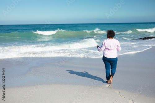 Old woman walking at the beach