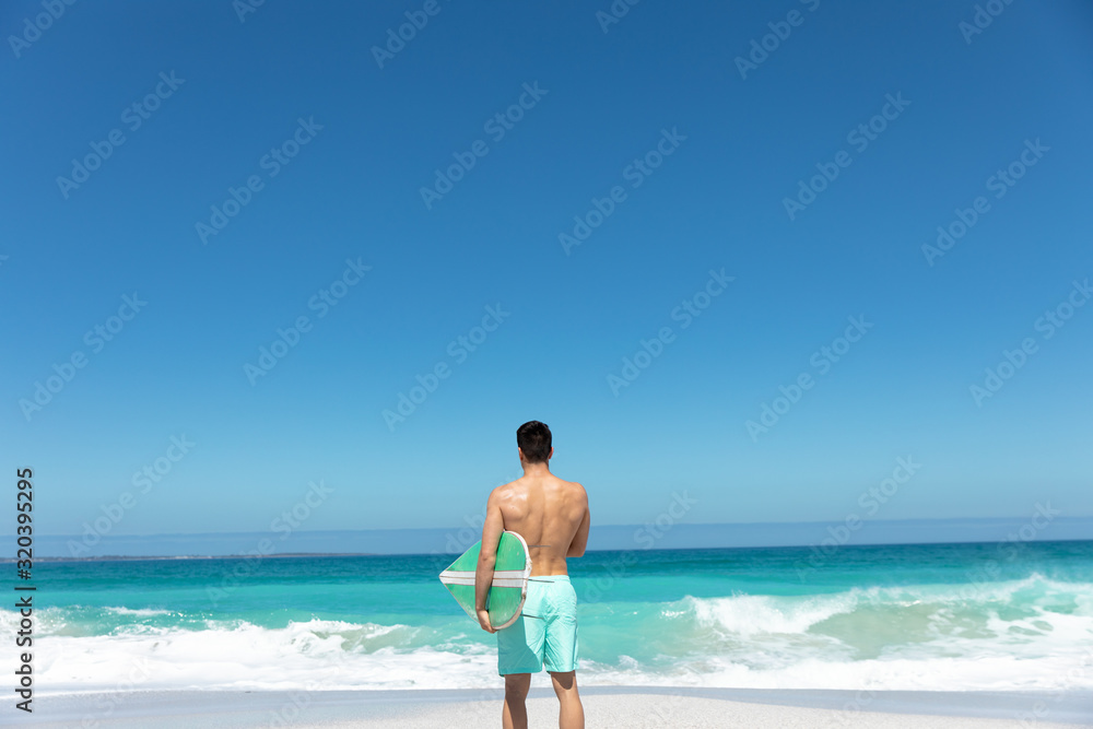 Young man with surfboard at the beach Young man with surfboard at the beach