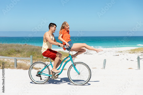Young couple with bike at the beach © WavebreakMediaMicro