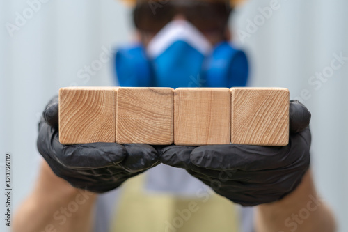 Industrial worker or architector or builder or engineer holding four clean wooden cubes in hands. Industry Construction Background Template Work Safety Concept. photo