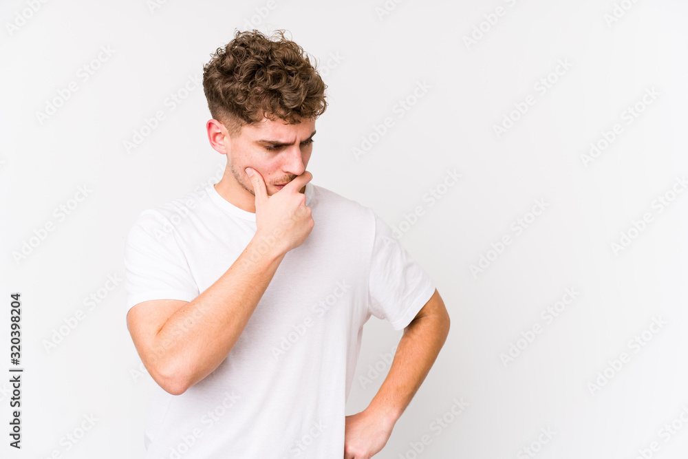 Young blond curly hair caucasian man isolated looking sideways with doubtful and skeptical expression. Young blond curly hair caucasian man isolated looking sideways with doubtful and skeptical expression.
