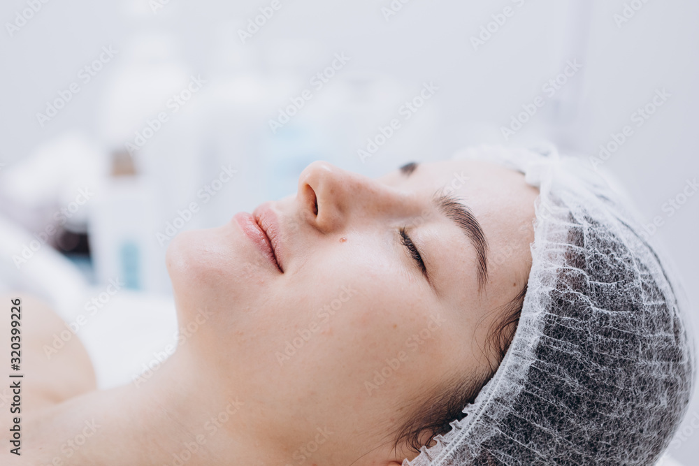 01.02.2020 Kyiv, Ukraine: portrait of a young female client who came to the cosmetologist to do a spa treatment on the face (massage, peeling and mask).Beauty and self care concept 01.02.2020 Kyiv, Ukraine: portrait of a young female client who came to the cosmetologist to do a spa treatment on the face (massage, peeling and mask).Beauty and self care concept