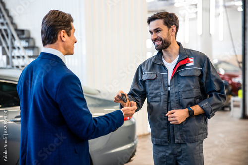 Professional mechanic looking at a pleased customer
