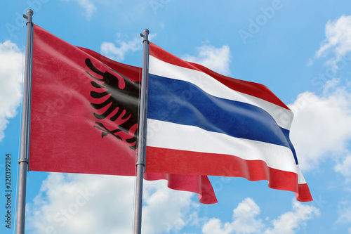 Thailand and Albania flags waving in the wind against white cloudy blue sky together. Diplomacy concept  international relations.