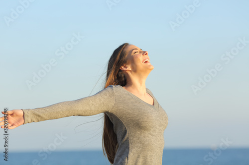Happy woman celebrating good day on the beach