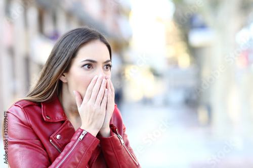Shocked woman looking away in the street