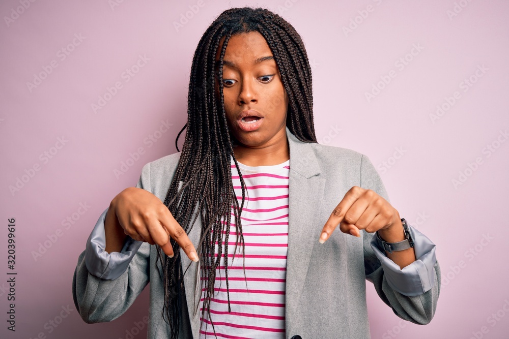 Young african american business woman standing over pink isolated ...