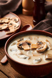 Bowl of mushroom soup on a wooden table vertical frame