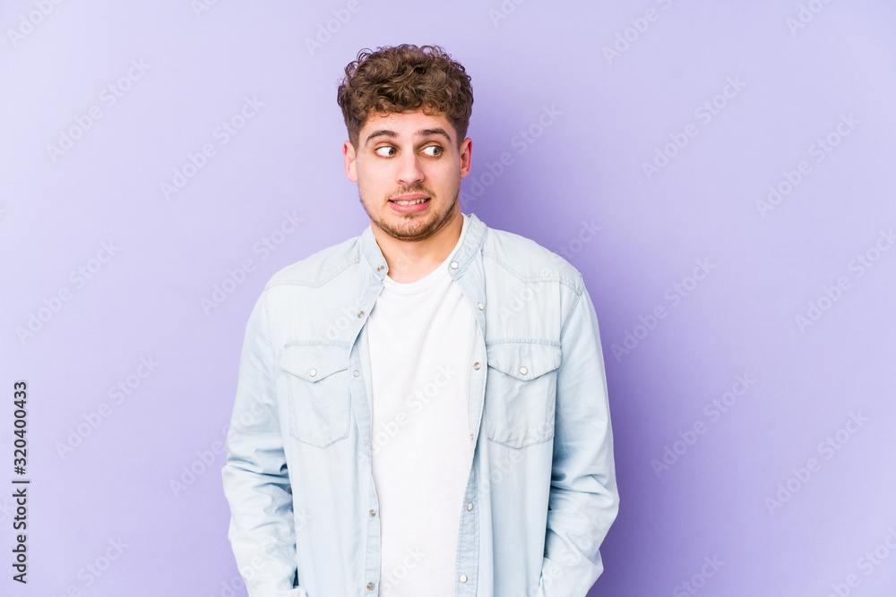Young blond curly hair caucasian man isolated confused, feels doubtful and unsure. Young blond curly hair caucasian man isolated confused, feels doubtful and unsure.