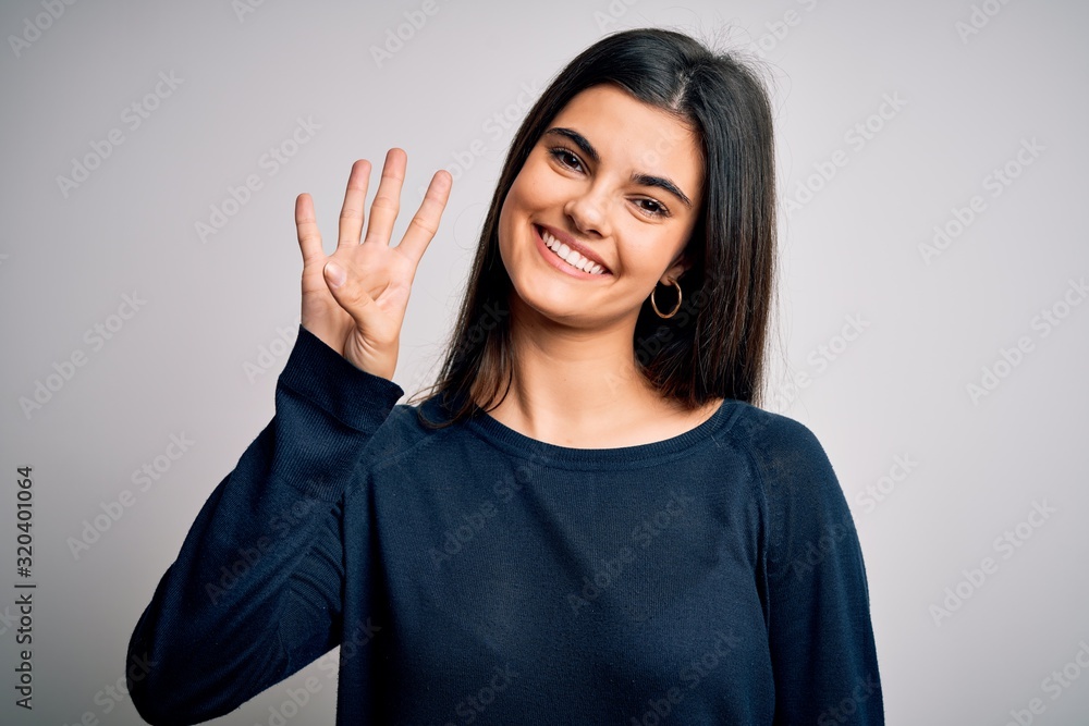 Young beautiful brunette woman wearing casual sweater standing over white background showing and pointing up with fingers number four while smiling confident and happy. Young beautiful brunette woman wearing casual sweater standing over white background showing and pointing up with fingers number four while smiling confident and happy.