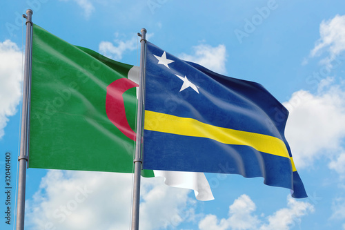 Curacao and Algeria flags waving in the wind against white cloudy blue sky together. Diplomacy concept, international relations.