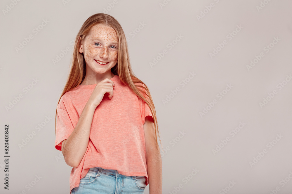 Inclusive Beauty. Girl with freckles standing isolated on grey posing smiling playful Inclusive Beauty. Girl with freckles standing isolated on grey posing smiling playful