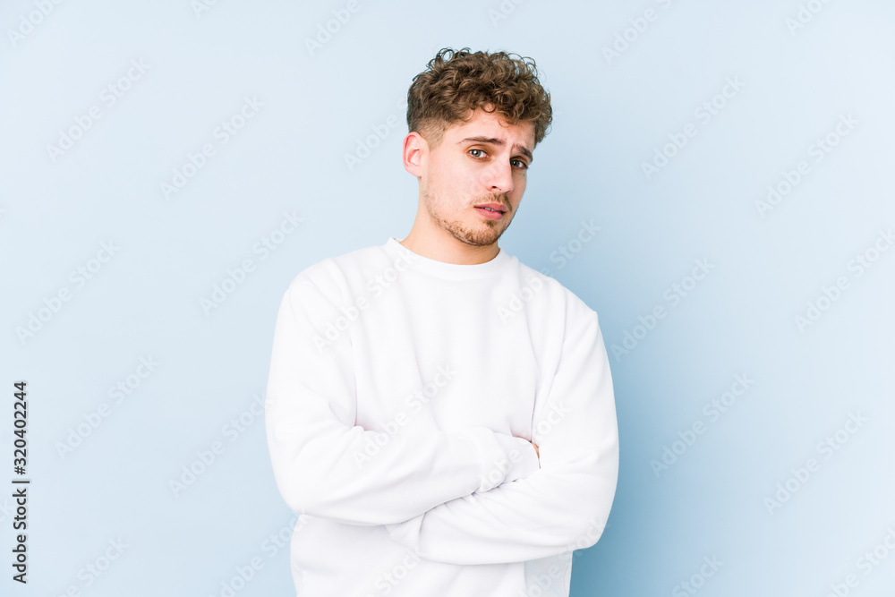 Young blond curly hair caucasian man isolated suspicious, uncertain, examining you. Young blond curly hair caucasian man isolated suspicious, uncertain, examining you.