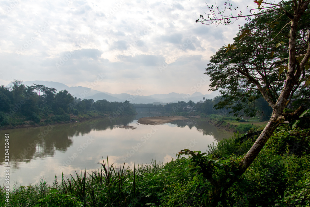 Paisaje del río Nam Khan bordeando la capital de Laos con el cielo reflejado